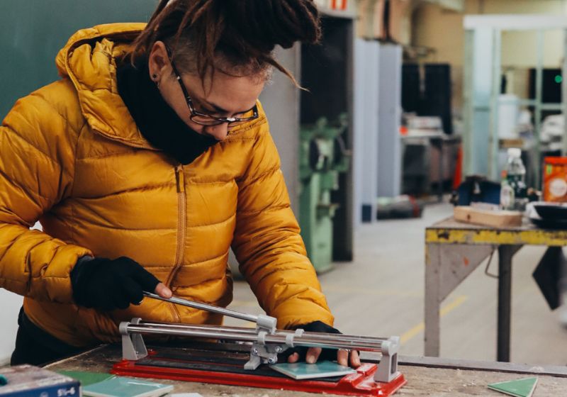 Elizabeth cuts tiles in the Habitat Women workshop